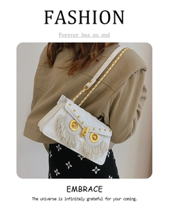 Detail of white owl-shaped crossbody bag with quilted pattern, fringe, and gold chain strap
