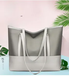 Detail of a large capacity contrast color tote bag with gray and beige patchwork design