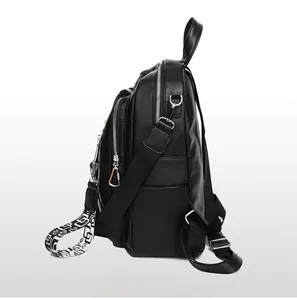 Side view of black faux leather backpack with multiple zipper layers and woven strap