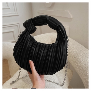 Détail du sac croissant plissé noir avec poignée nouée et bandoulière chaîne argent