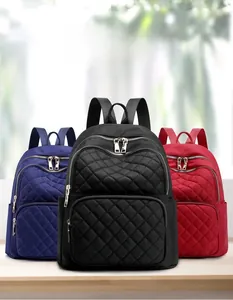 Detail view of nylon quilted backpacks in black, navy blue, and burgundy with metal zippers