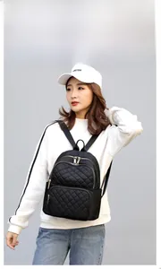 Detail of black quilted nylon backpack featuring silver metal zippers on outdoor travel bag