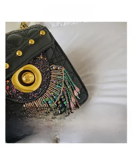 Close-up of quilted leather bag with owl-style colorful rhinestones and beaded tassels