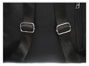 Detail of adjustable woven strap with silver metal buckle on black lychee leather bag