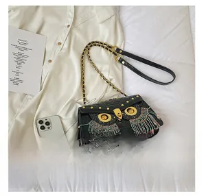 Close-up of owl-shaped quilted crossbody bag with beaded tassels and gold chain detail