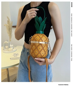 Détail du sac ananas en cuir avec rivets dorés et poignée en forme de feuille