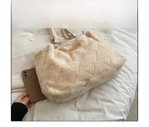 Beige plush heart tote bag shown with a smartphone for size comparison reference