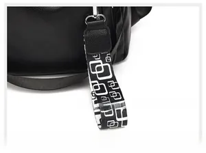 Detail shot of black pebbled leather backpack with silver hook and geometric strap