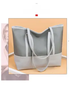 Detail of a large two-tone oxford tote bag in grey-green and off-white with slim straps