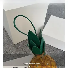 Détail de la poignée en feuilles vertes et texture ananas jaune du sac bandoulière
