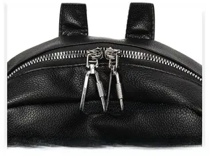 Close-up of dual silver zippers and litchi texture on a black soft leather backpack