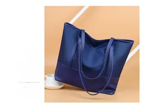Detail shot of navy blue nylon tote bag with reinforced base and shiny waterproof texture