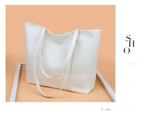 Detailed view of white faux leather tote bag showing reinforced base stitching and long straps