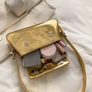Metallic gold mirror finish baguette bag showing interior storage capacity with daily items