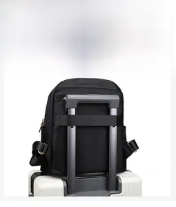 Detail view of the luggage strap on the back of a black nylon diamond quilted backpack