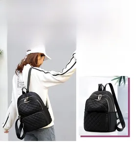 Close-up of quilted nylon backpack featuring golden zippers and logo printed straps