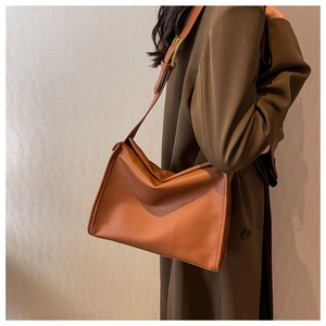 Caramel lychee pattern leather tote bag shown with brown trench coat for autumn style