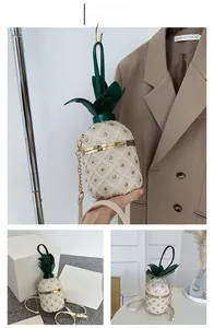 Détail du sac créatif en forme d'ananas blanc crème avec chaîne dorée et feuilles vertes