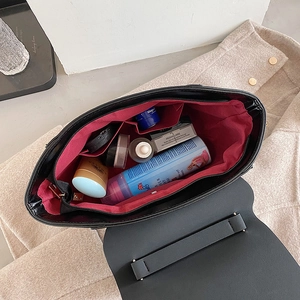 Frosted black crossbody bag with red interior lining and spacious inner compartments