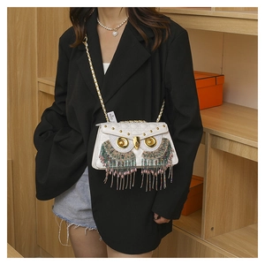 Detail view of white quilted owl crossbody bag with colorful beads and gold chain strap