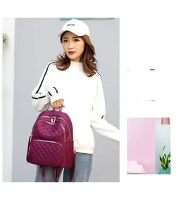 Detail of purple quilted nylon backpack showing the elegant diamond stitching and textures