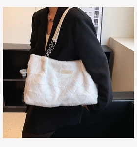 Detail of white plush tote bag with heart quilting and silver chain shoulder strap