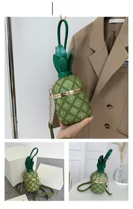 Détail du sac seau en forme d'ananas vert avec clous dorés et bandoulière chaîne