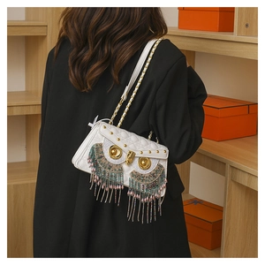 Detail of owl crossbody bag with colorful bead embroidery and metal tassels