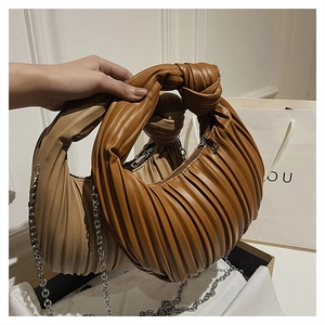 Détail des sacs froncés avec poignées nouées et chaînes argentées en marron et beige