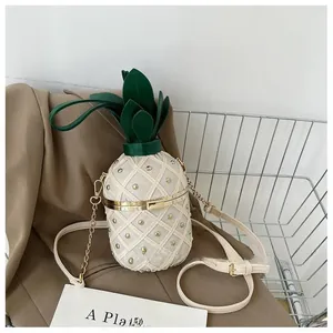 Détail du sac seau ananas avec matelassage beige et rivets dorés élégants