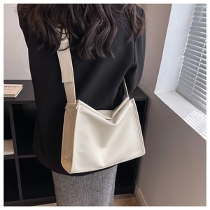 Detail of cream white leather shoulder bag with wide strap on model back view