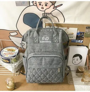 Macro shot of grey multi-functional mummy backpack with quilted diamond stitching and branding
