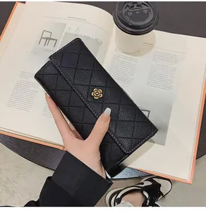 Detailed view of black quilted long wallet with elegant golden petal buckle