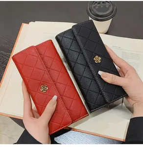 Detail of red and black quilted leather long wallets featuring gold camellia metal buckles