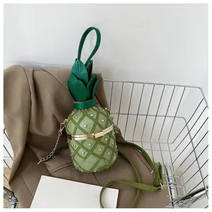 Détail du sac seau ananas vert avec motifs matelassés et ornements de perles