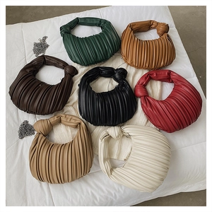 Détail de sacs croissants plissés multicolores avec poignées nouées et chaînes argent