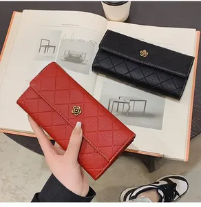 Close-up of quilted long wallet featuring a metallic camellia flower on the red flap