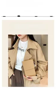 Detailed view of mini light brown leather crossbody bag styled with a beige trench coat