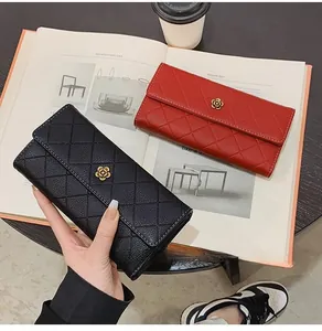 Close-up of quilted long wallets in black and red with gold floral hardware details