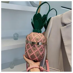 Détail du sac seau ananas rose avec rivets dorés et poignée en forme de feuille verte