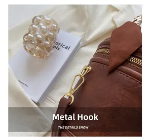 Détails des crochets dorés et du foulard en soie imprimé sur un sac seau marron rétro