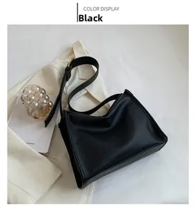 Detail of lychee pattern leather handbag with golden metal buckle on a desk