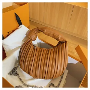 Détail du sac demi-lune plissé marron avec poignée nouée et fine chaîne argentée