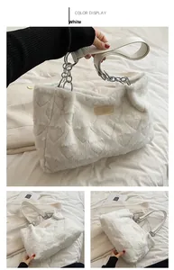 Close-up of white plush heart-patterned tote with silver chain and leather strap