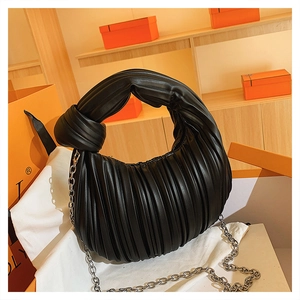 Détail du sac plissé noir avec anse nouée surdimensionnée et bandoulière en chaîne