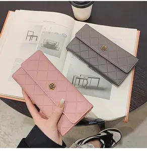 Detail of pink and grey quilted wallets with metal camellia flower on a magazine