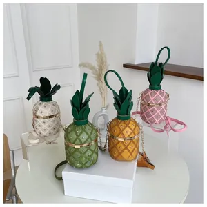 Détail de sacs seaux en forme d'ananas avec clous dorés et design de feuilles vertes