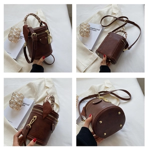 Détails du sac cylindrique avec poignée en foulard léopard et clous de protection au fond