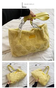 Close-up of yellow fuzzy heart tote bag featuring silver chain and faux leather handles
