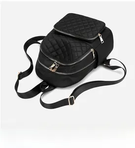 Close-up of black nylon quilted backpack with elegant gold metal zippers and hardware